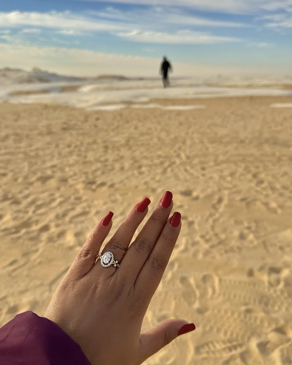 Sanjona’s engagement ring on her hand, on a beach