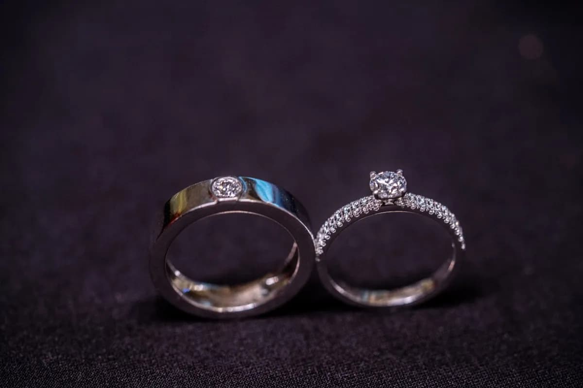 A man’s band set with a diamond beside a pavé engagement ring